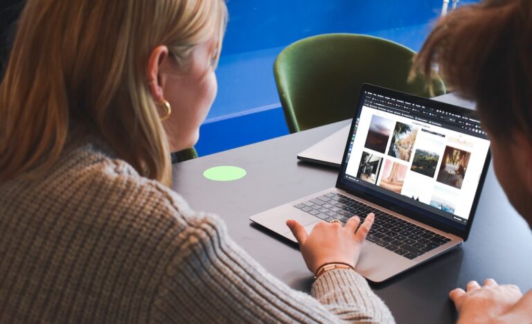 woman in gray sweater using macbook pro