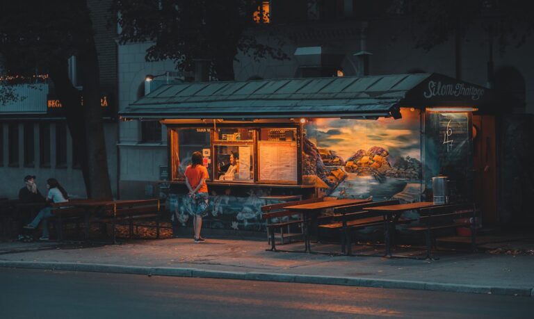 brown wooden table and chairs near store during night time