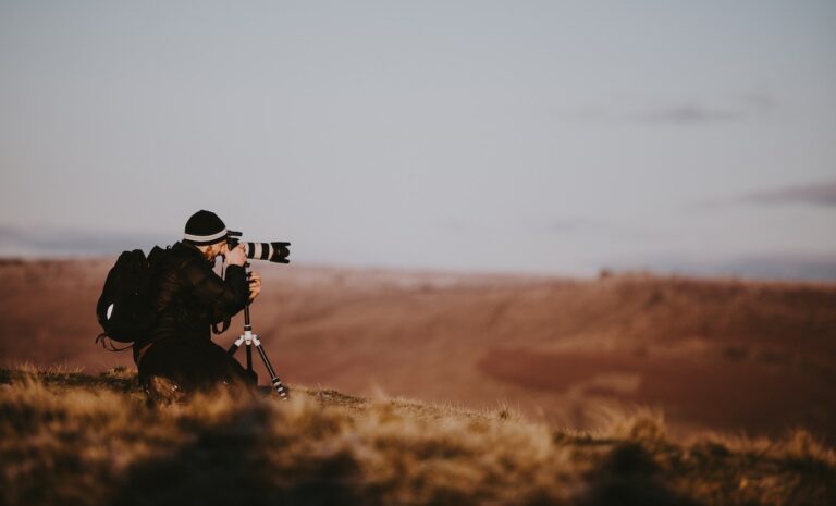 man using black DSLR camera during daytime