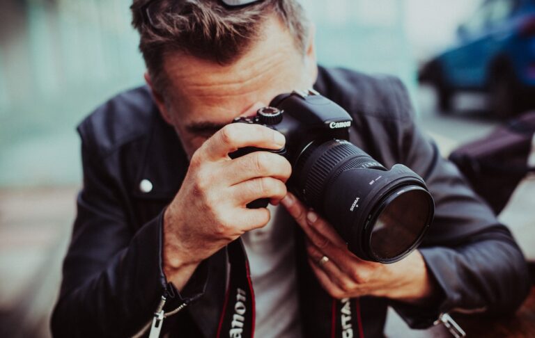 man holding up Canon DSLR camera