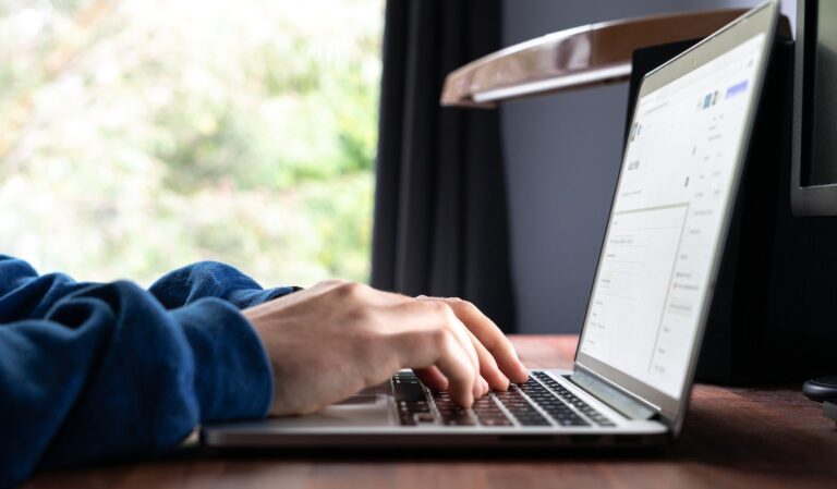 person using macbook pro on table