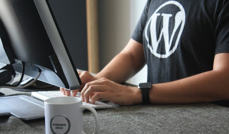 person in black and white t-shirt using computer